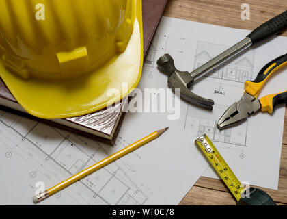 Bau plan mit Bau Helm, Buch, Hammer, Bleistift, Messgerät und Zangen auf hölzernen Tisch Stockfoto