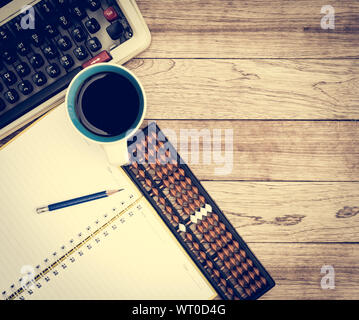 Büro Schreibtisch Hintergrund. Kaffee, Notizblock, Bleistift, Abacus und Schreibmaschine auf vintage Schreibtisch aus Holz Stockfoto