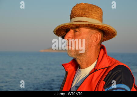 Portrait der ältere Mann in der Sonnenaufgang auf dem Meer Stockfoto