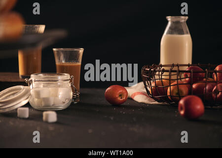 Krapfen Zutaten mit Milch, mini Äpfel, Zucker über schwarzen Hintergrund Stockfoto