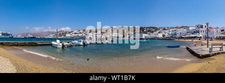 Schönen Meereslandschaft mit Sandstrand verankert Boote und weißen Häusern am Strand von Mykonos in Griechenland an einem sonnigen Tag Stockfoto