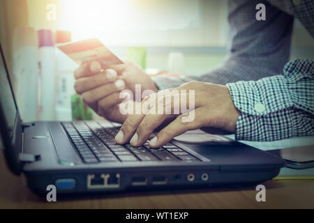 Geschäftsmann mit Laptop Zahlung per Kreditkarte im Amt zu online. Stockfoto