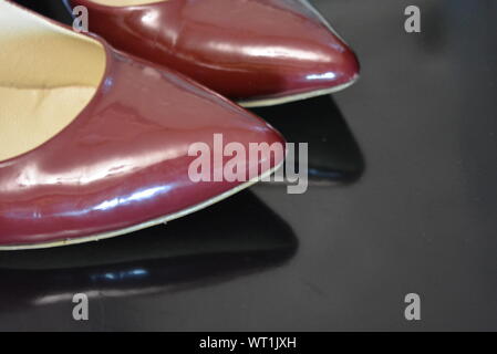 Der reine modische Stil, dunkle Kirschlackschuhe mit spitzer Spitze, Damenschuhe mit Absatzschuhen aus echtem Leder. Stockfoto