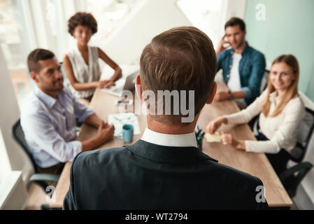 Rückansicht des Business Mann in formale Abnutzung etwas Diskussion mit seinen Kollegen bei einer Sitzung im Büro. Brainstorming Stockfoto