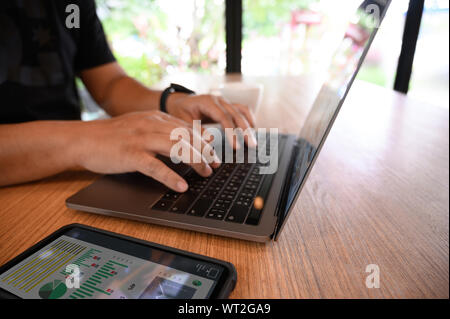 Mann mit einem Computer Laptop, Computer, Desktop-PC der menschlichen Hand im Büro zu arbeiten Stockfoto