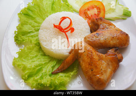 Vietnamesische Küche gebratene Hähnchenflügel Reis mit Salat und Tomatenscheibe Stockfoto