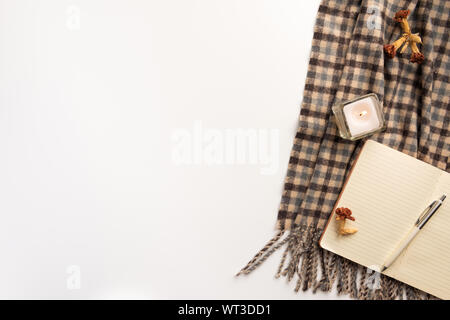 Notebook, Schal, Kerze öffnen, auf weißem Hintergrund. Flach. Stockfoto