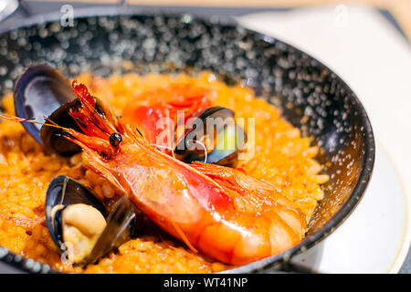 Valencianische Paella mit Reis, Safran und Meeresfrüchte in einer speziellen Pfanne serviert. Typisches Rezept der spanischen Küche. Stockfoto