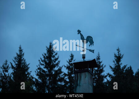 Bad Hindelang, Deutschland. 11 Sep, 2019. Ein wetterhahn steht auf einem Dach vor bewölkter Himmel bei Sonnenaufgang. Credit: Lino Mirgeler/dpa/Alamy leben Nachrichten Stockfoto