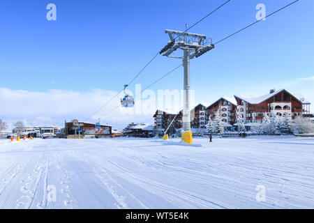 Bansko, Bulgarien - Januar 22, 2018: Winter Skigebiet mit Skipiste, Gondelbahn Hütten, Häuser und Menschen Warteschlange Stockfoto