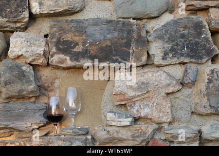 Gläser Wein auf einer alten Steinmauer in Toskana, Italien Stockfoto
