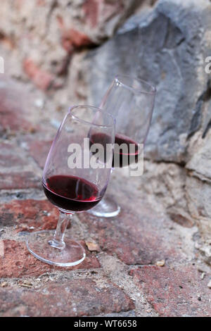 Gläser Wein auf einer alten Steinmauer in Toskana, Italien Stockfoto