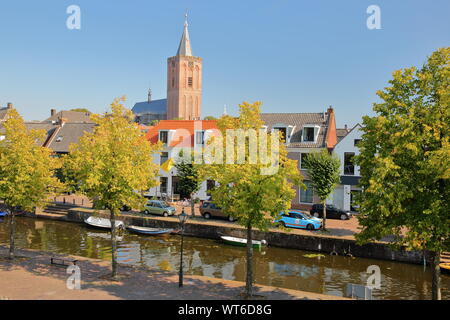 Historische Häuser innerhalb der Festungsstadt Naarden, Niederlande, mit dem Glockenturm der Grote Kerk Kirche im Hintergrund Stockfoto