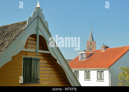 Historische Häuser innerhalb der Festungsstadt Naarden, Niederlande, mit dem Glockenturm der Grote Kerk Kirche im Hintergrund Stockfoto