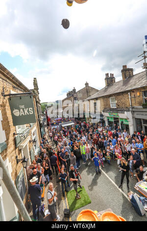 8. September 2019. Ramsbottom, Nr Bury, Lancashire, England. Die Welt Blutwurst Throwimg Meisterschaften außerhalb des Royal Oak Public House (jetzt bekannt als die Eichen in der Lancashire Vikllage. Die Kandidaten stehen auf einem 'Golden Grid" Die angeblich durch Dampfzug von einem geheimen Ort, die feierlich die Hauptstraße vorgeführt worden. Sie haben drei Versuche, ein Cluster von Yorkshire Pudding aus einem Sockel 20 Meter Gerüst mit 3Chadwick's schwarz Bury Pudding mit einem underark werfen oder 'lob' lösen. Die Teilnehmer reisen aus Übersee teil zu nehmen. Bild Stockfoto