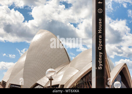Sydney Opera House Segel während des Tages mit Beschilderung und blauer Himmel mit weißen Wolken. Stockfoto
