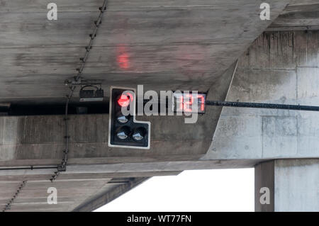 Das rote Licht vom Signal Pole mit der digitalen Countdown Anzahl an der Kreuzung unter der Autobahn Brücke. Stockfoto