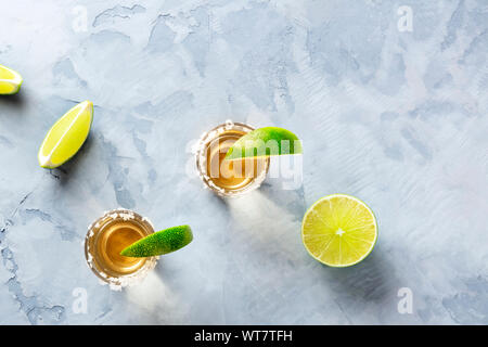 Golden tequila Shots mit Limonen und Salz Felgen, geschossen von oben mit Copyspace Stockfoto