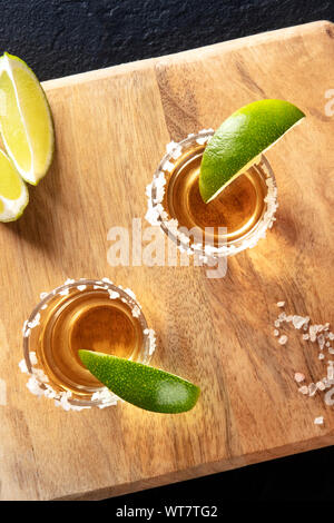 Golden tequila Schüsse mit Salz und Limette Felgen Scheiben, Overhead Nahaufnahme Stockfoto