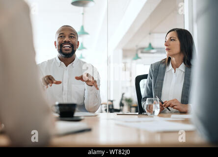 Lächelnd afrikanischen amerikanischen Geschäftsmann, Gespräche mit Kollegen während einer Konferenz Stockfoto