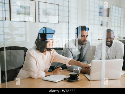Diverse Geschäftsleute, die an einem Notebook arbeitet in einem Büro Stockfoto