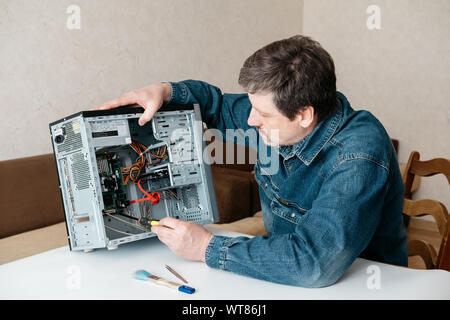 Computer Techniker Ingenieur mit Schraubendreher in seiner Hand ist die Instandsetzung der Personal Computer. Mitte der erwachsene Mann, computer Wartungstechniker, Professi Stockfoto