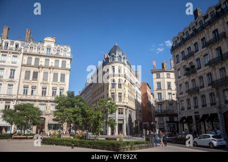 LYON, Frankreich - 13. JULI 2019: Fußgänger gehen auf Platz Jacobins in Lyon, Frankreich, ein Gebäude im Haussmann und einigen kommerziellen Shop ein Stockfoto