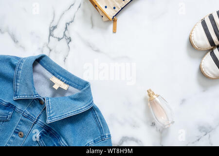 Schreibtisch der Schönheit Blogger mit feminine Jeans Jacke, Kosmetiktasche, Duft Flasche Parfüm, topmodische Sandalen. Retro altmodische Frauen clo Stockfoto