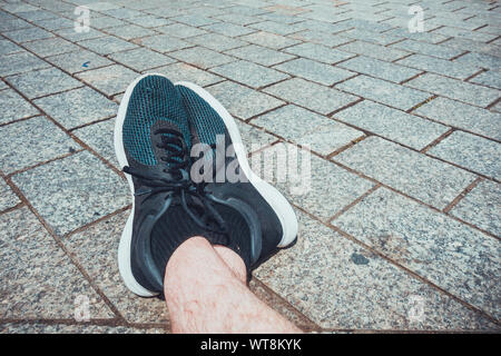 Mann auf seinen Sport Schuhe Stockfoto
