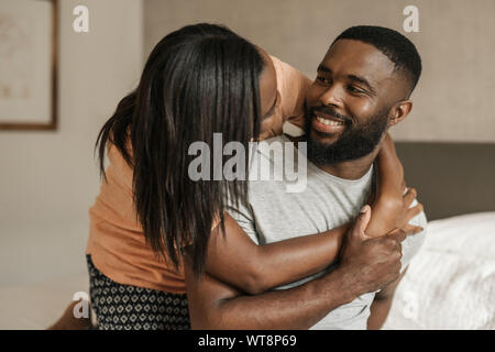 Herzlichen afrikanischen amerikanischen Paar sitzt auf ihrem Bett tragen Schlafanzug Stockfoto