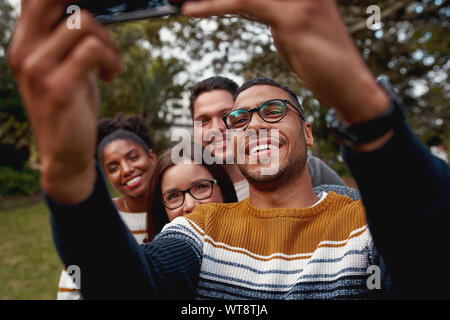 Lächelnde Amerikanische brasilianischen Mann selfie auf Handy genießen die Zeit zusammen mit seinen Freunden Stockfoto