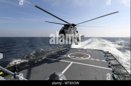 Rostock, Deutschland. 11 Sep, 2019. Während die naval Herbst Manöver "nördlichen Küsten' Helikopter ea King' zieht aus der Corvette "Oldenburg" der Deutschen Marine. Das Manöver mit mehr als 40 Schiffen findet vom 06. -18.09.2019. Das Ziel der Übung, die eine gute zwei Wochen dauern und rund 3000 Soldaten aus 18 Nationen betreffen, ist das Meer zu schützen Routen unter einem fiktiven UN-Mandat. Quelle: Bernd Wüstneck/dpa-Zentralbild/dpa/Alamy leben Nachrichten Stockfoto