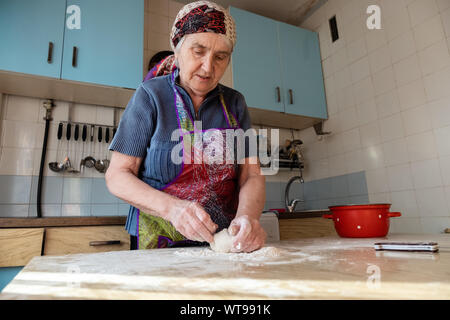 Ältere Frau kneten den Teig in Ihrem Haus Küche, Großmutter kochen Backwaren, frisches Brot, leckere Torte Stockfoto