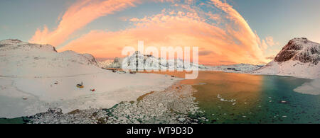 Antenne drone Panorama Foto. Schönen Sonnenuntergang über den Bergen und Meer von den Lofoten. Reine, Norwegen. Winterlandschaft mit herrlichen Farben. Stockfoto