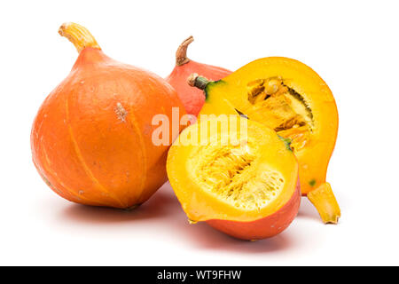 Ganze und halbe Red Kuri Squash auf weißem Hintergrund Stockfoto