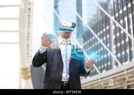 Digital zusammengesetzten Bild des Geschäftsmannes tragen Virtual Reality Simulator beim Stehen in der Stadt Stockfoto