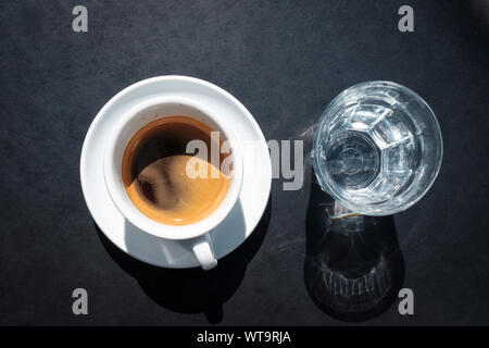 Doppelter Espresso und ein Glas Wasser auf dem Tisch oben, Ansicht von oben Stockfoto