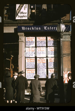 Männer und eine Frau liest Schlagzeilen posted in Straßenecke Fenster von Brockton Enterprise Zeitungsredaktion am Heiligabend, Brockton, Massachusetts, USA Stockfoto