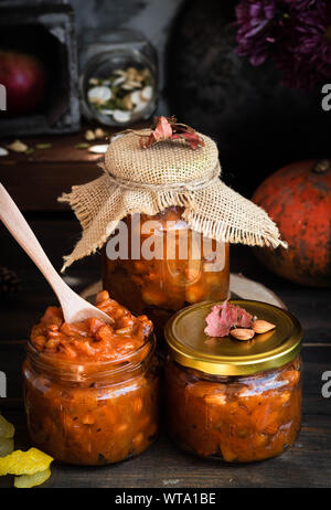 Kürbis Marmelade auf einem dunklen Hintergrund im Landhausstil. Herbst Ernte. Gemütliche Herbst noch leben. Hausgemachte Vorbereitungen für den Winter. Stockfoto