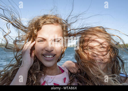 Ungepflegtes Haar Zwillinge lächelnd während strong Gale Stockfoto