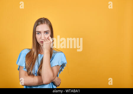 Mädchen Brünette in blauen T-Shirt über isolierte orange Hintergrund zeigt Emotionen Stockfoto