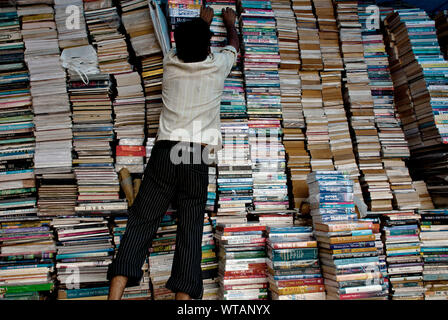 Man organisiert einen gebrauchten Buchhandlung Stockfoto