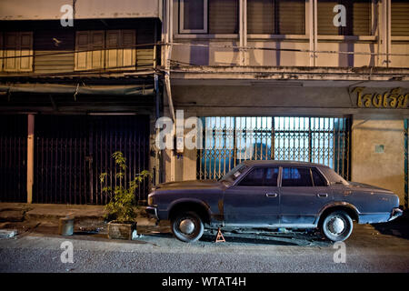 Altes Auto in einer zentralen Straße von Bangkok geparkt Stockfoto