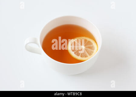 Tasse Tee mit in Scheiben geschnittenen Zitrone closeup auf weißem Hintergrund Stockfoto