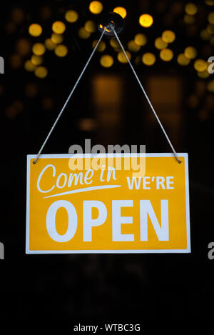 Offene Zeichen auf Glas Fenster mit Bokeh Lichter im Hintergrund Stockfoto