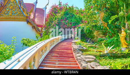 Die schmale aufsteigende Treppe führt auf den Gipfel des Hügels zum Golden Mount Temple entlang der malerischen tropischen Vegetation mit zahlreichen Skulpturen, Bangkok, Stockfoto