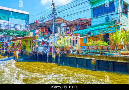 BANGKOK, THAILAND - 24 April 2019: Die schäbige Wohnhäuser am Ufer des khlong Saen Saep mit Pflanzen in Töpfen entlang Pflaster, am 24. April in Stockfoto