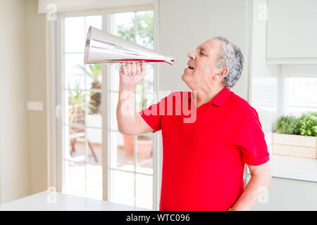 Älterer Mann shouthing durch vintage Metall Megaphon aufgeregt Stockfoto