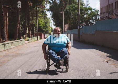 Behinderte Menschen im Rollstuhl auf der Straße Stockfoto