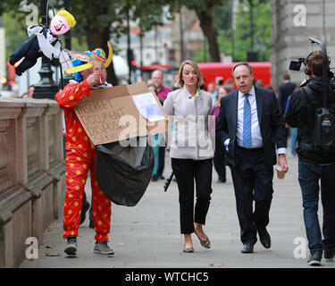 Westminster, London, 11. Sep 2019. Nigel Dodds, Chef der DUP im Unterhaus und stellvertretende Vorsitzende der DUP, in Westminster mit BBC politischer Korrespondent Laura Kuenssberg und pro-europäischen Demonstrant in "Boris der Clown' Outfit. Credit: Imageplotter/Alamy leben Nachrichten Stockfoto